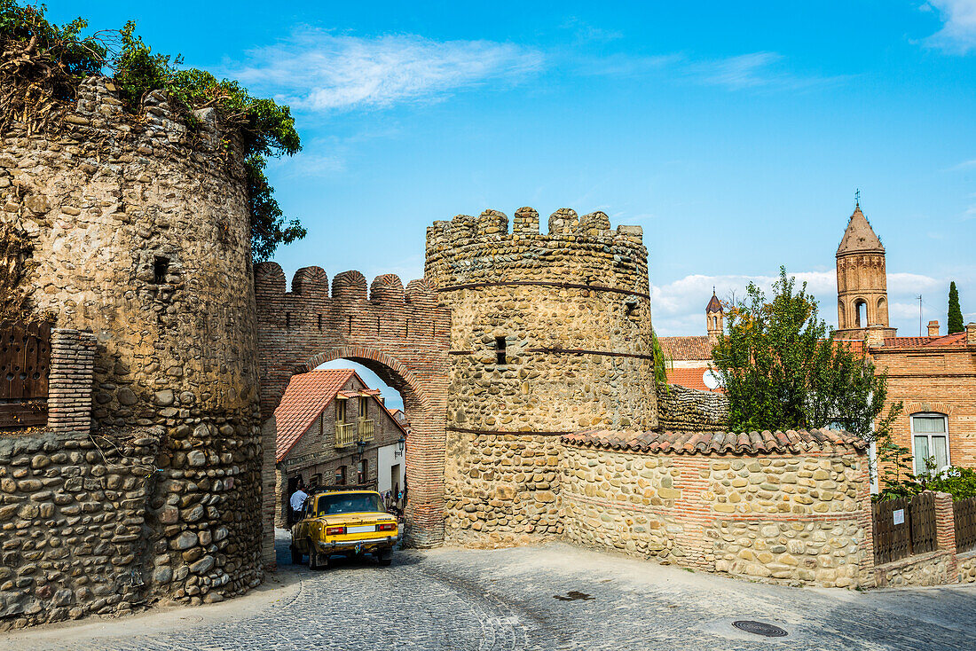 Kakheti, Arch, Gate, Old, Stone, Wall, Entrance, Driving, Yellow, Car, Pedestrian, Blue Sky, History, Remains, Remnants, 18th Century, Fortification, Tower, Watchtower, Sighnaghi, Georgia, Road, Building, , Blue, Sky, 18th, Century, Horizontal, Travel Des