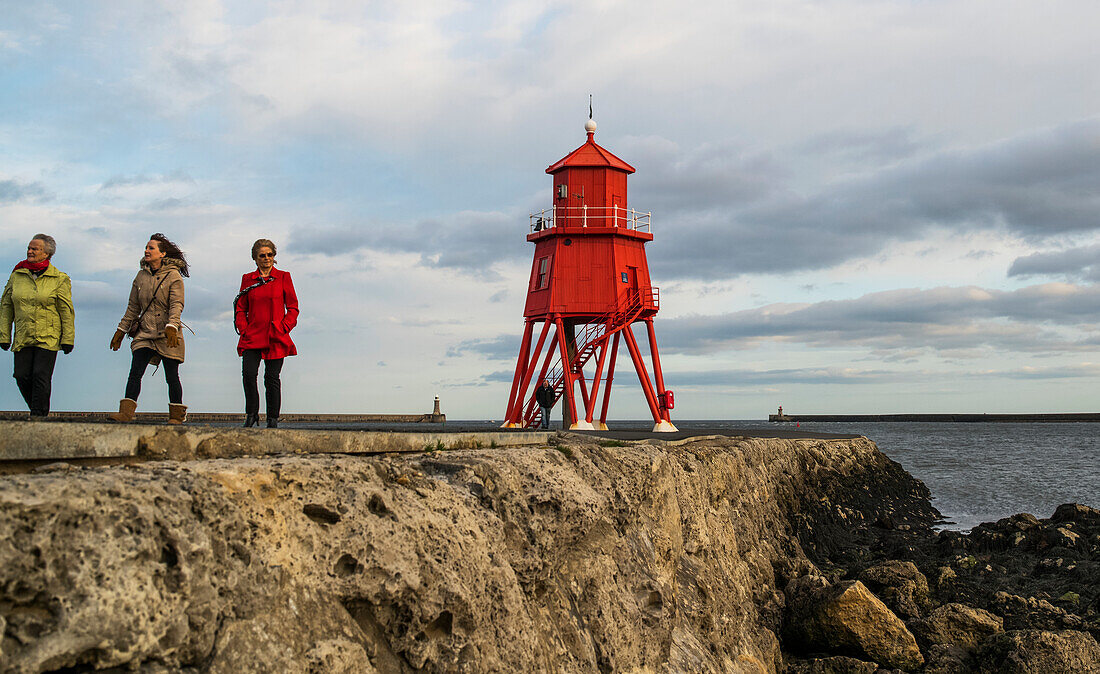 'Touristen zu Fuß auf einem Pier und Herd Groyne Leuchtturm; South Shields, Tyne und Wear, England'