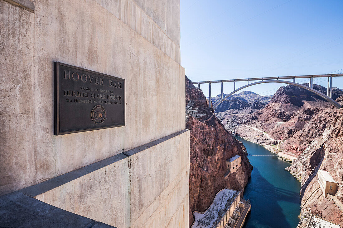 Eine Plakette zum Gedenken an den Bau des Hoover-Staudamms wird am Hoover-Damm-Ausflug mit Blick auf die Mike O'Callaghan-Pat Tillman Memorial Bridge und Canyon unten gezeigt. Arizona, Vereinigte Staaten von Amerika