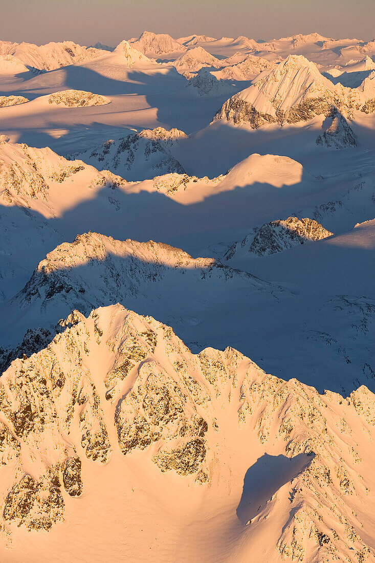 Gipfel einer schneebedeckten Bergkette glühend rosa bei Sonnenuntergang, Kachemak Bay State Park, Alaska, Vereinigte Staaten von Amerika