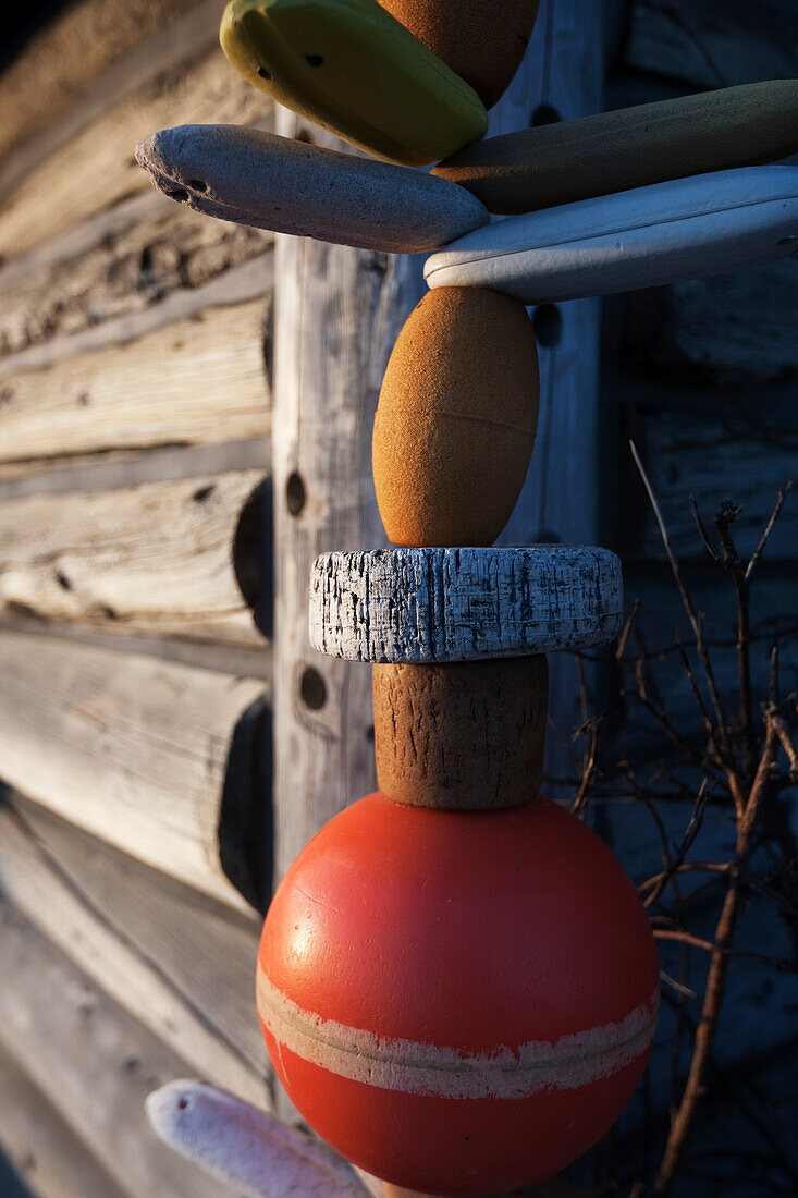 A colourful buoy hanging beside a log wall, Alaska, United States of America