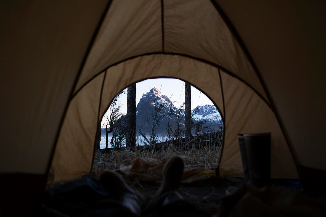 Blick von innen ein Zelt durch die Tür zu den schroffen Gipfeln der Kenai Berge, Kachemak Bay State Park, Alaska, Vereinigte Staaten von Amerika