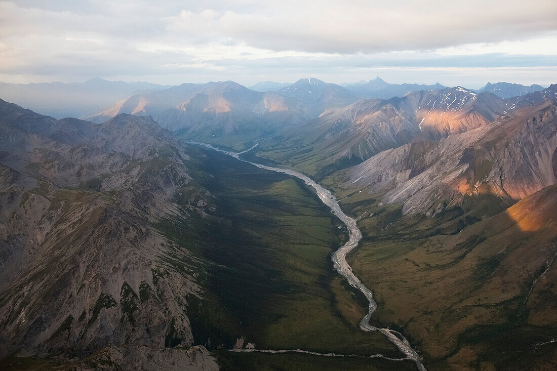 Ein Fluss, der durch ein Tal in einer schroffen Gebirgskette führt, Alaska, Vereinigte Staaten von Amerika