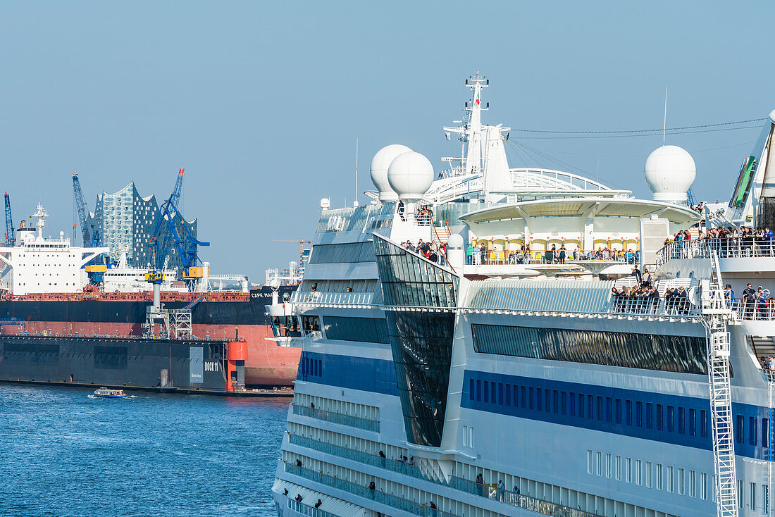 Ein Kreuzfahrtschiff im Hamburger Hafen mit der Elbphilharmonie im Hintergrund, Hamburg, Deutschland