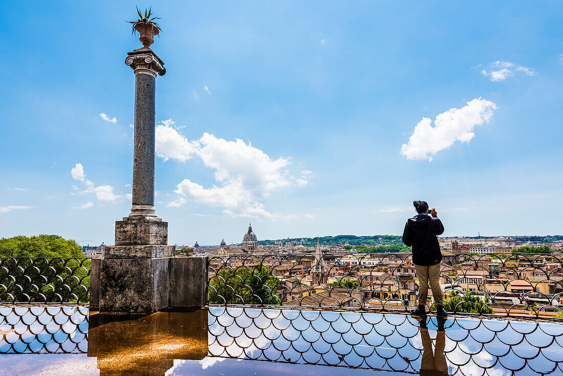 Ein Mann schießt Fotos vom Blick von der Terrazza Viale del Belvedere , Rom, Latium, Italien