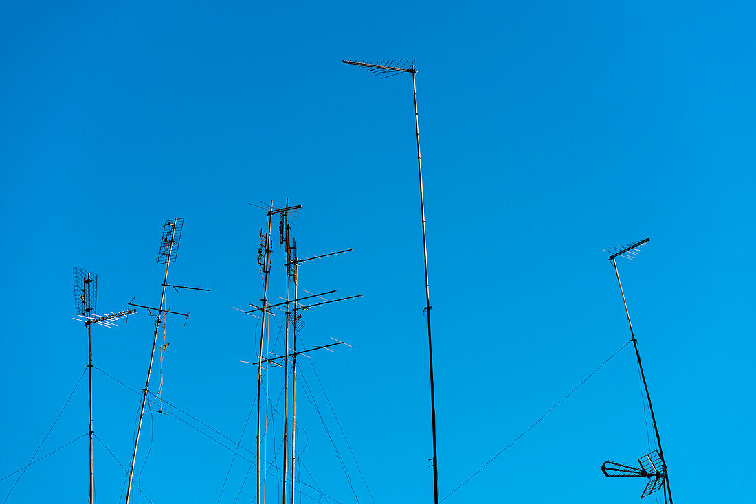 Die typischen Antennen für analogen Empfang auf einem Wohnhaus vor blauem Himmel, Rom, Latium, Italien