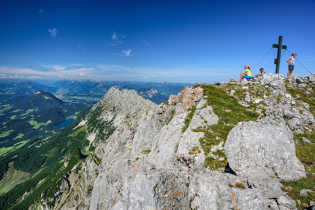 Three persons having a break at summit of Sonneck, Sonneck, Kaiser range, Tyrol, Austria