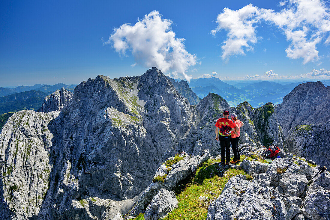 Two persons at summit of Sonneck looking towards Kaiser range, Sonneck, Kaiser range, Tyrol, Austria
