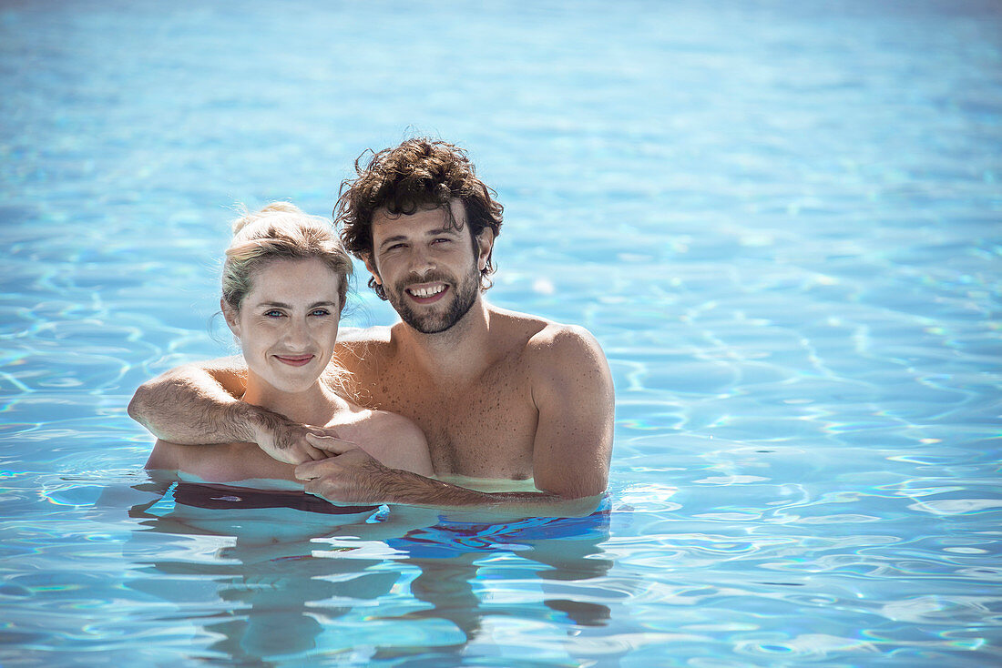 Couple relaxing together in pool, portrait