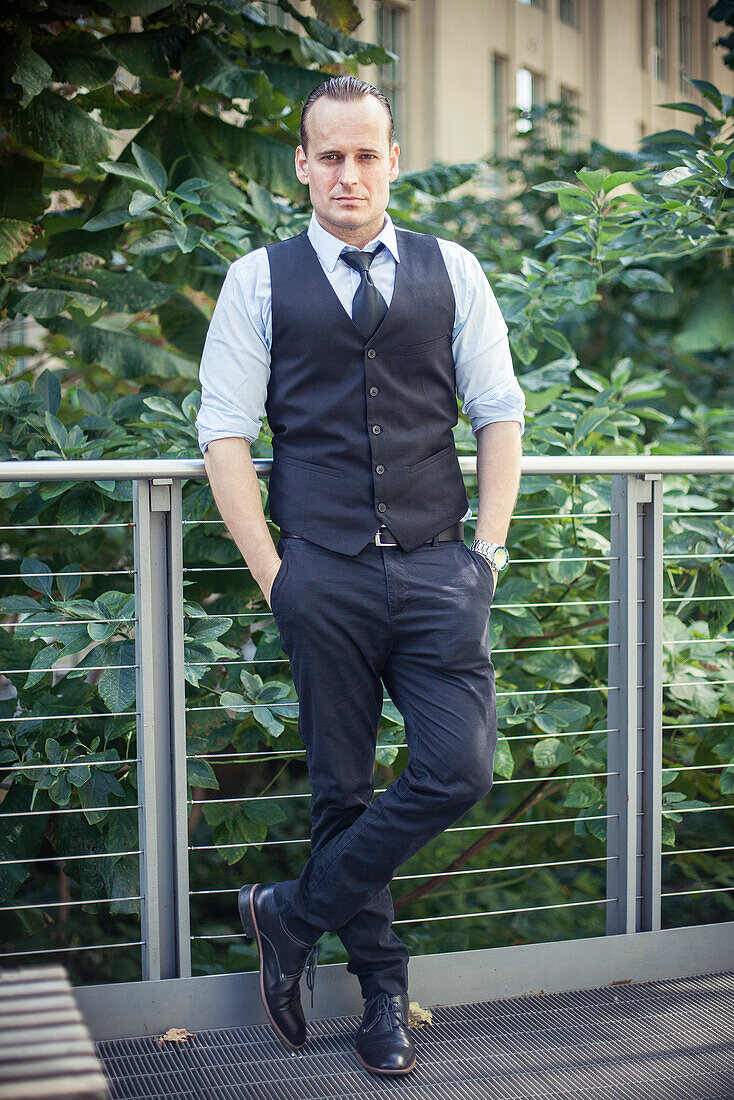 Well-dressed man standing on balcony, portrait