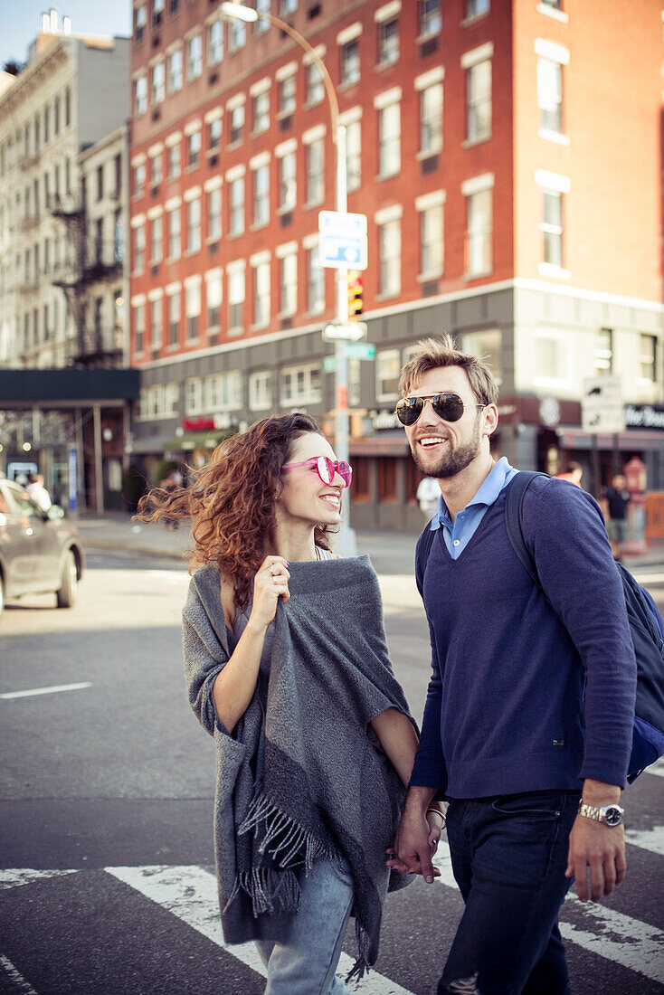 Couple crossing city street together