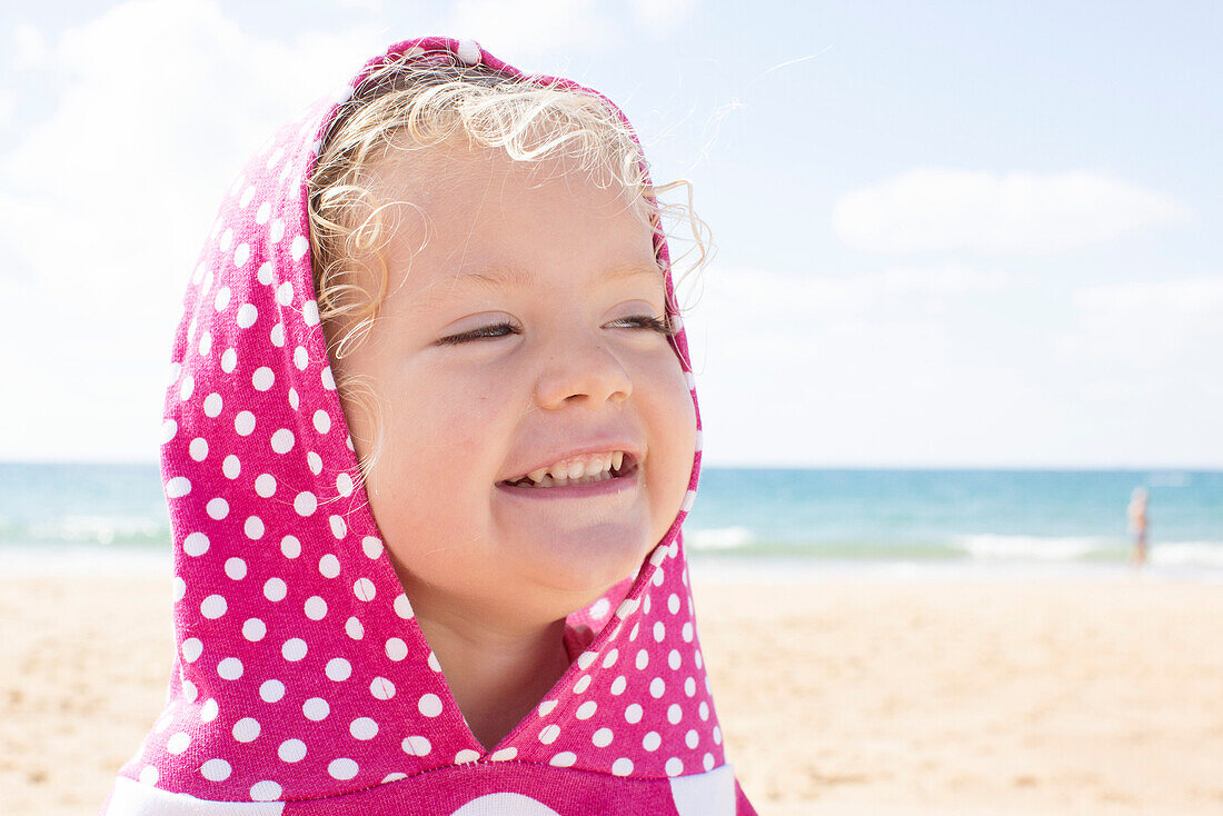 Girl wearing hood with polka dots at beach