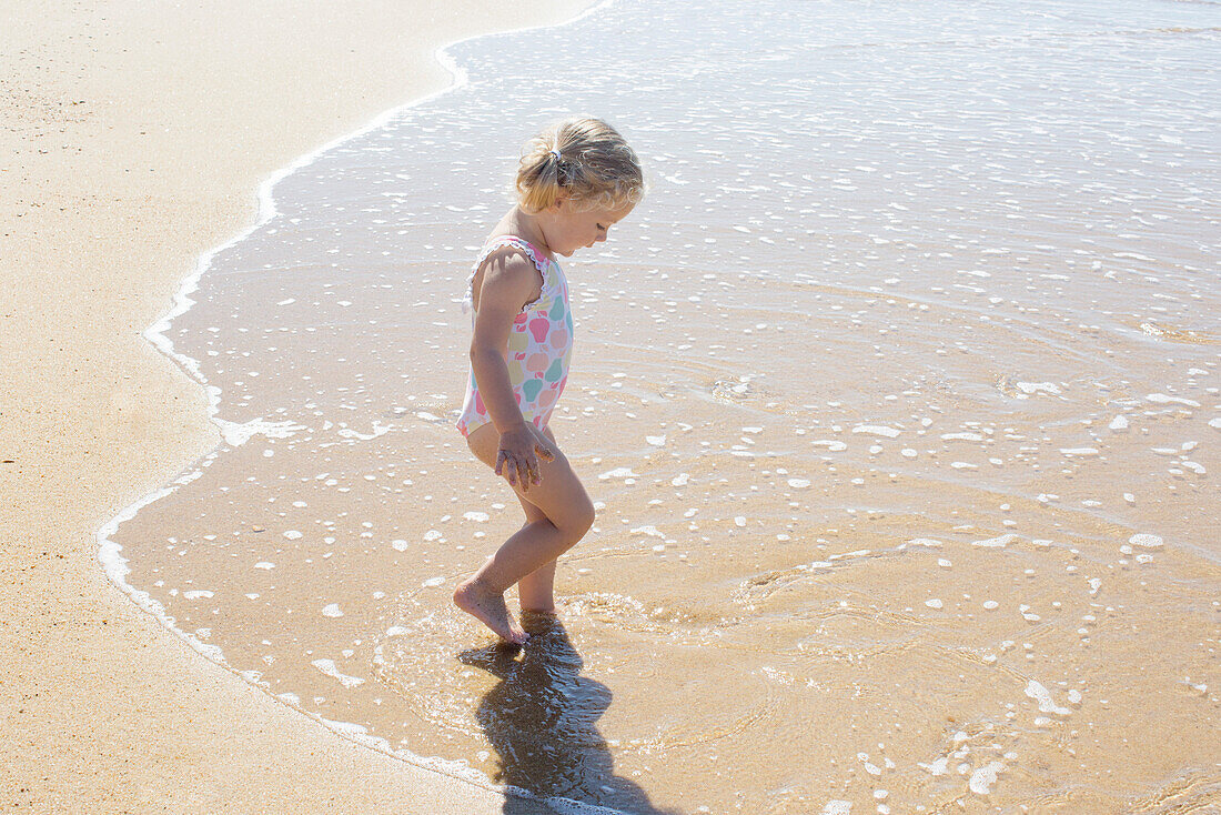 Little girl wading in the surf