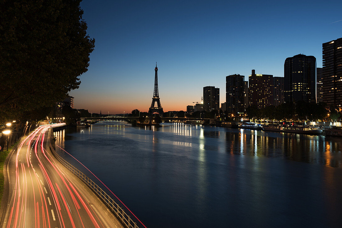 Light Trails auf einer Straße entlang der Seine in der Dämmerung, Paris, Frankreich