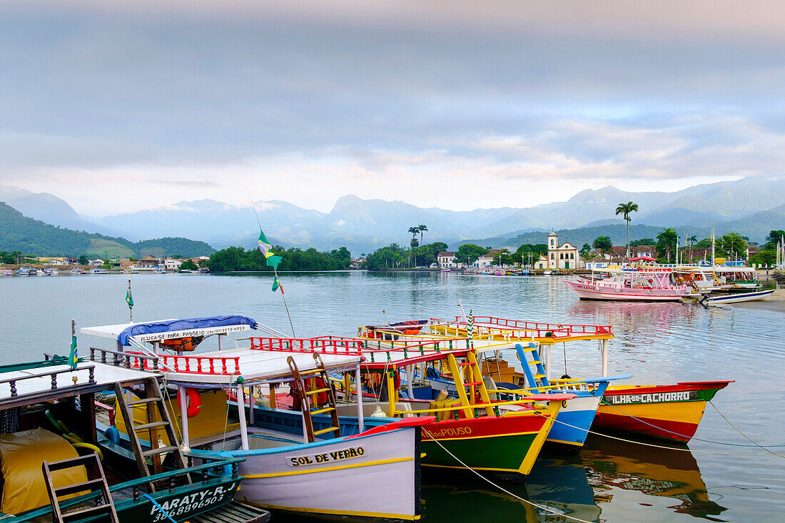 Fishing boats in Paraty village with the mountains of the Serra da Bocaina behind, Rio de Janeiro state, Brazil, South America