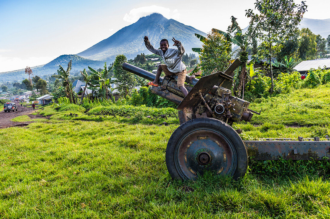 Boys posing on abandoned artillery in the Virunga National Park, Democratic Republic of the Congo, Africa