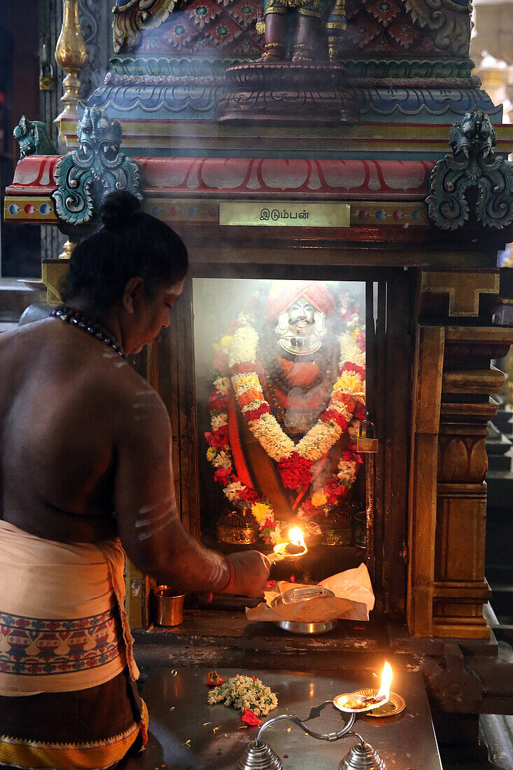 Priest with an arthi (lighted camphor) performing morning puja ceremony, Sri Thendayuthapani Hindu Temple (Chettiars' Temple), Singapore, Southeast Asia, Asia