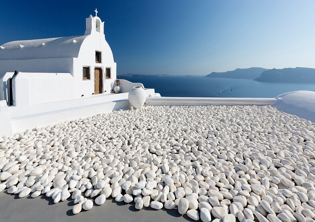 Kleine weiß getünchte Kirche gegen blaues Meer und Himmel, Finikia, in der Nähe von Oia, Santorini, Kykladen, Griechische Inseln, Griechenland, Europa