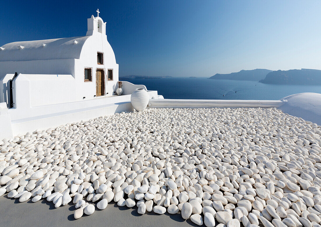 Small whitewashed church against blue sea and sky, Finikia, near Oia, Santorini, Cyclades, Greek Islands, Greece, Europe