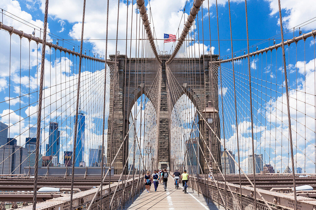 Tourists, cyclists on walkway, Brooklyn Bridge, Lower Manhattan skyline, New York skyline, New York City, United States of America, North America