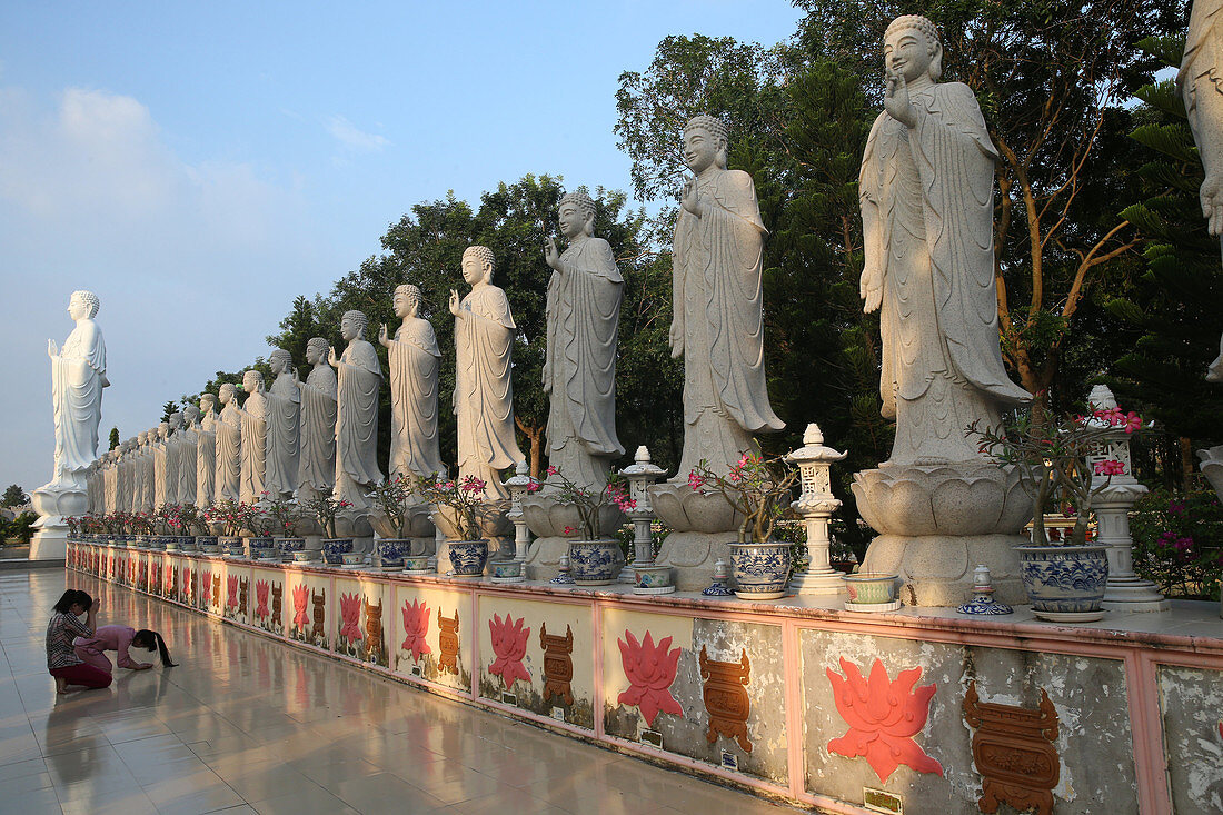 Frau betet vor Buddha Amitabha Statuen, Dai Tong Lam Tu buddhistischer Tempel, Ba Ria, Vietnam, Indochina, Südostasien, Asien