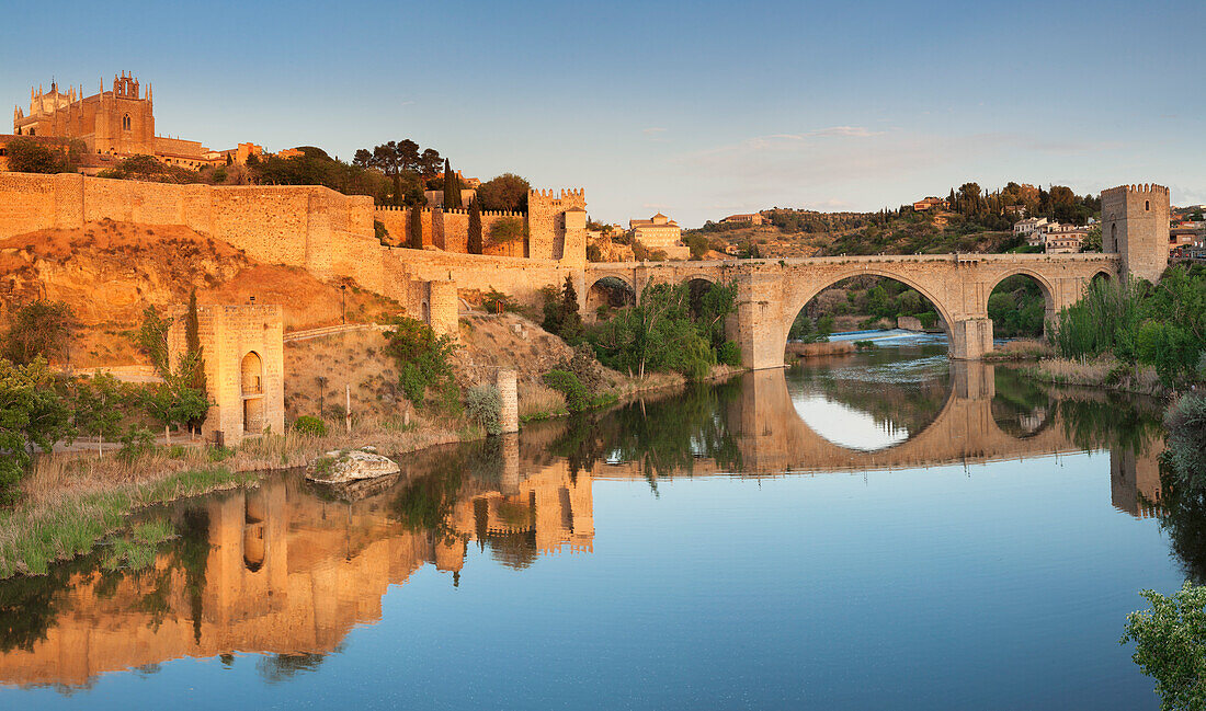 Puente de San Martin Bridge and San Juan des los Reyes Monastery reflected in the Tajo River, Toledo, Castilla-La Mancha, Spain, Europe