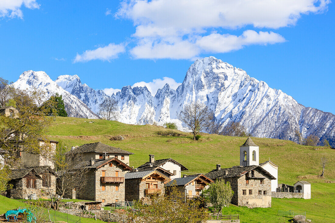 Alpendorf und Wiesen umrahmt von der verschneiten Spitze von Pizzo di Prata, Dalo, Chiavenna-Tal, Valtellina, Lombardei, Italien, Europa