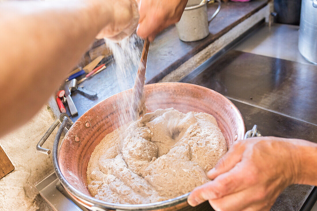 Chef bereitet die typische Polenta, San Romerio Alp, Brusio, Kanton Graubünden, Poschiavo Tal, Schweiz