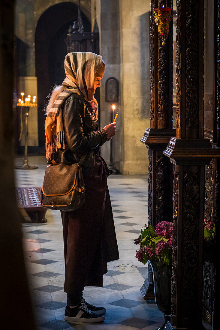 Woman praying in Sioni Cathedral of the Dormition, Tbilisi, Georgia, Caucaus, Eurasia