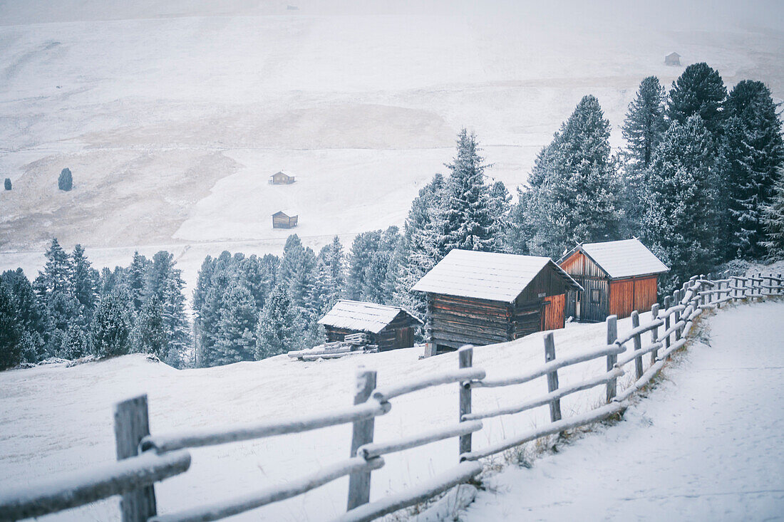 Einige schneebedeckte Häuser im Naturpark Puez-Geisler, Südtirol, Italien
