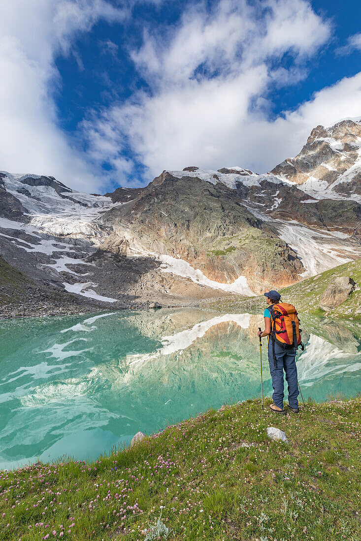 A girls looks the Locce Lake and the Grober Glacier at the foot of the East face of Monte Rosa Massif (Locce Lake, Macugnaga, Anzasca Valley, Verbano Cusio Ossola province, Piedmont, Italy, Europe)