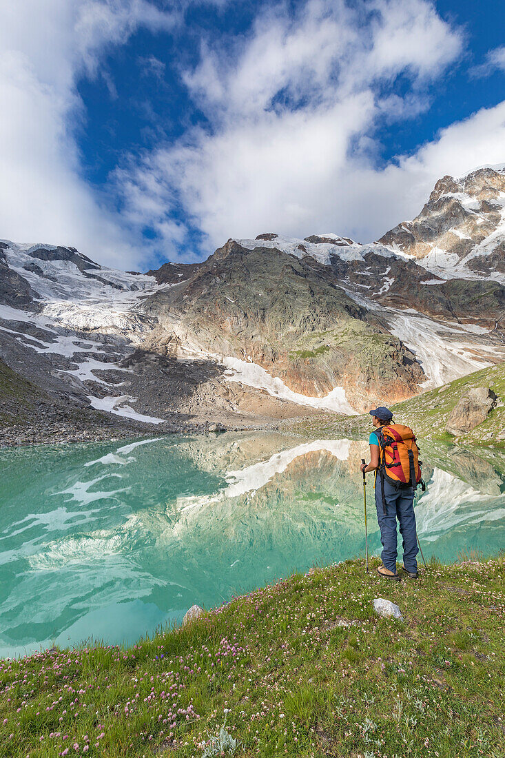 Ein Mädchen schaut auf den Locce-See und den Grober-Gletscher am Fuß der Ostwand des Monte-Rosa-Massivs (Locce-See, Macugnaga, Anzasca-Tal, Provinz Verbano Cusio Ossola, Piemont, Italien, Europa)