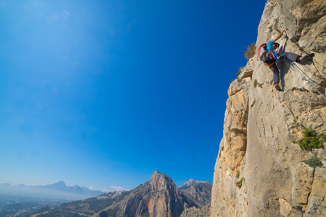 A man lead climbing a technical rock route in Costa Blanca Spain at Sierra de Toix.