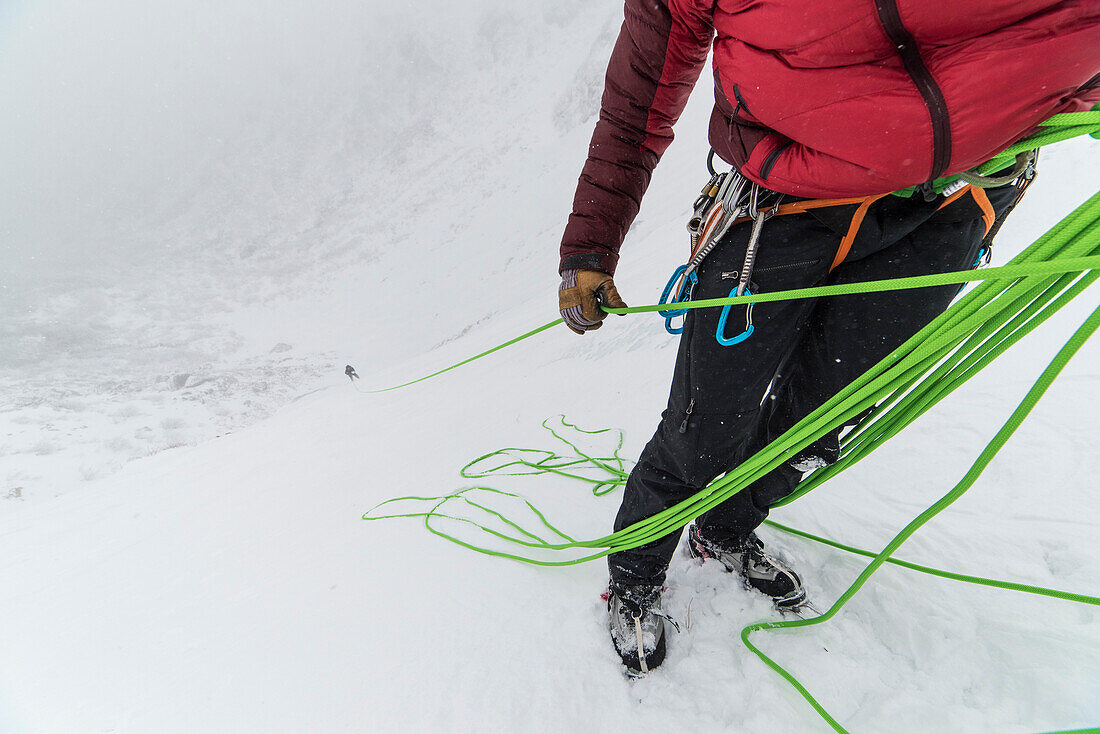 Ice climber belaying partner up to the belay