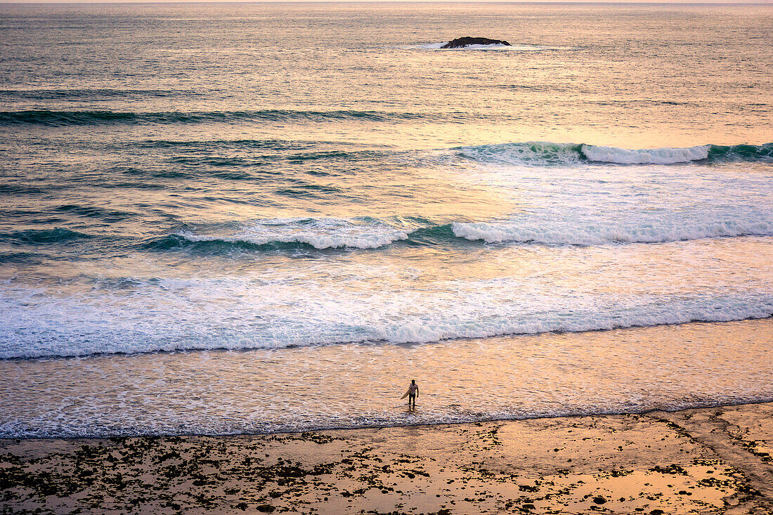 Surfer am Strand bei Sonnenuntergang