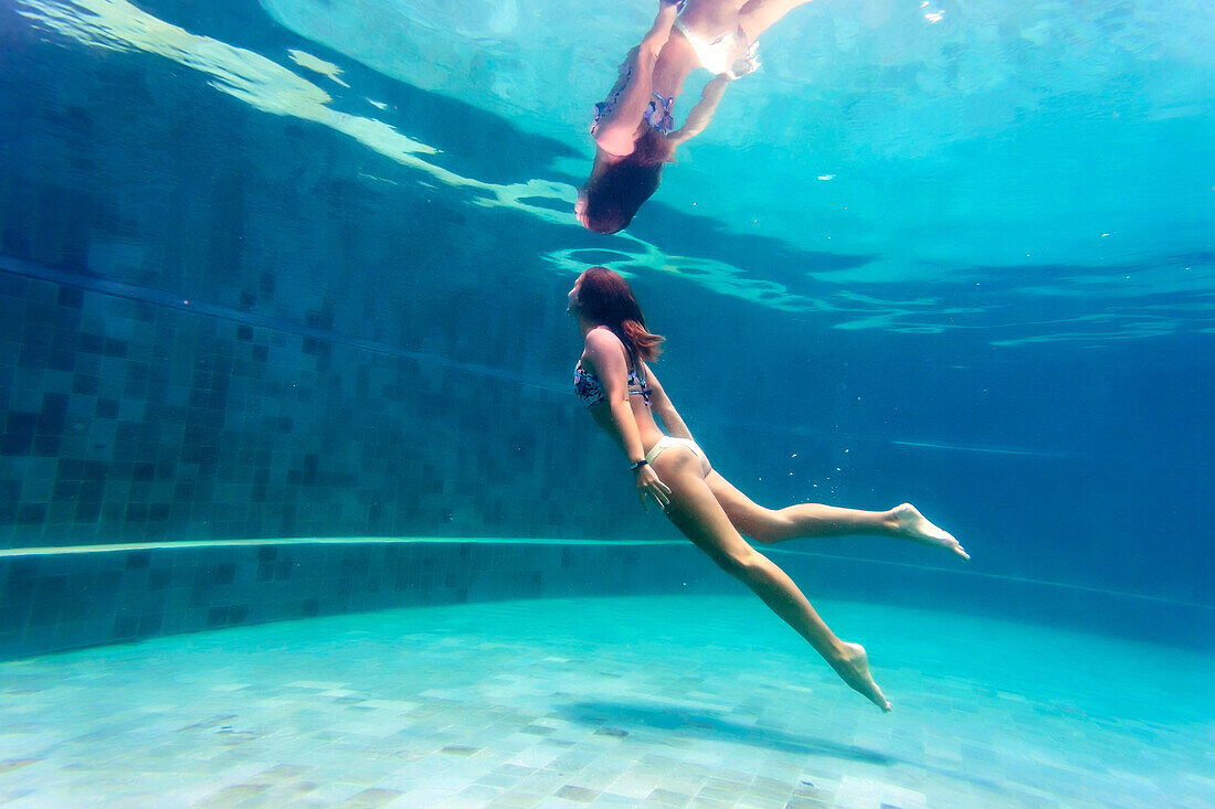 Junge Frau taucht im Schwimmbad