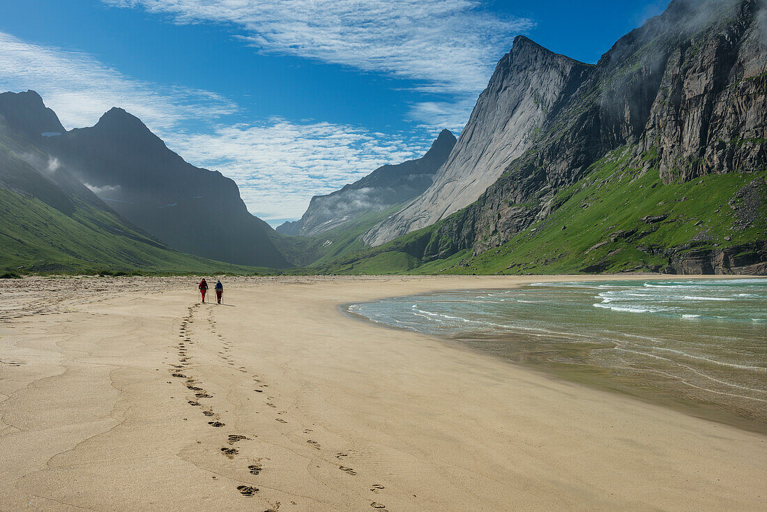 Zwei Wanderer hinterlassen Footprints im Sand am Strand von Horseid, Moskenesøy, Lofoten, Norwegen