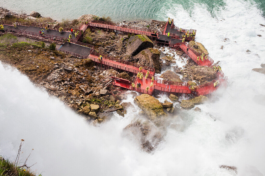 Touristen tummeln sich in gelben Plastik-Ponchos auf der Aussichtsplattform eines Niagarafalls auf der USA-Seite.