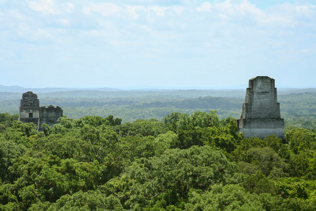 Ancient Maya ruins in Tikal, Guatemala stand above the forest below.