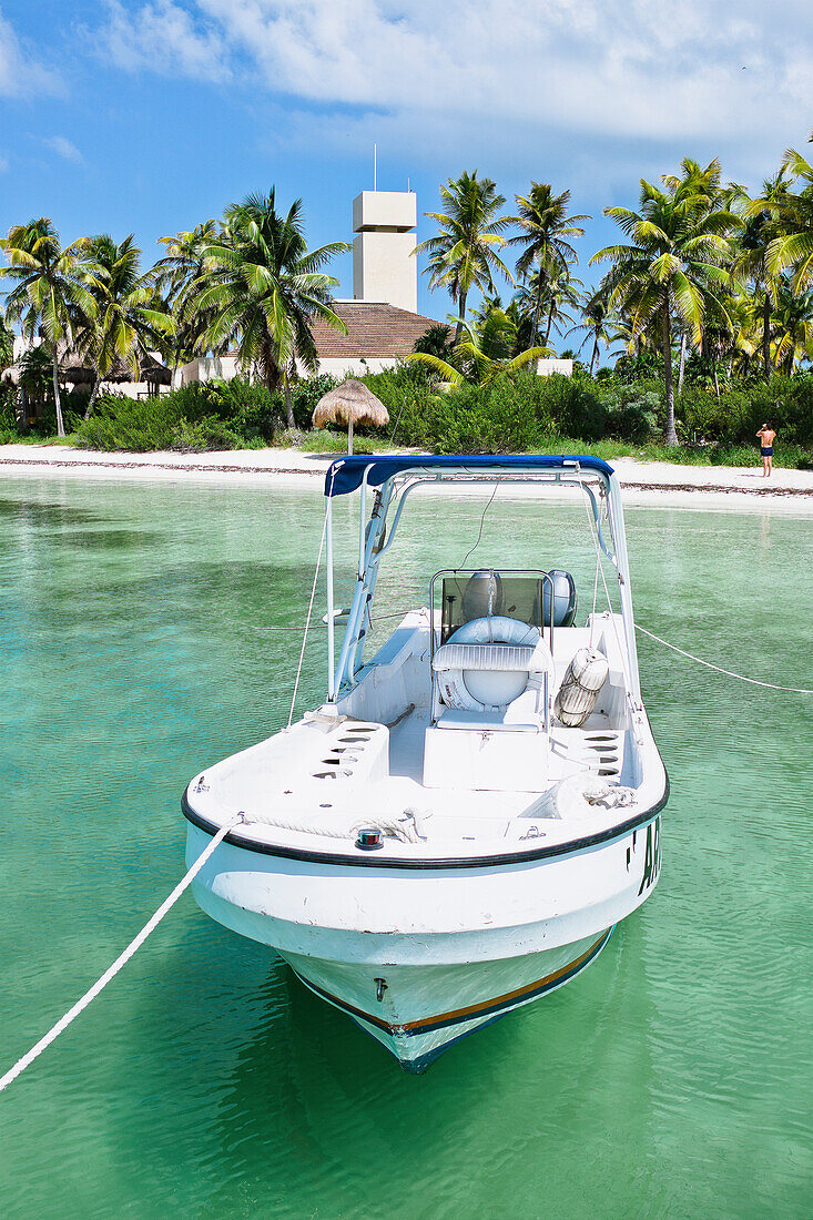 Motorboot auf dem Wasser mit Strand und Palmen im Hintergrund, Isla Contoy, Mexiko