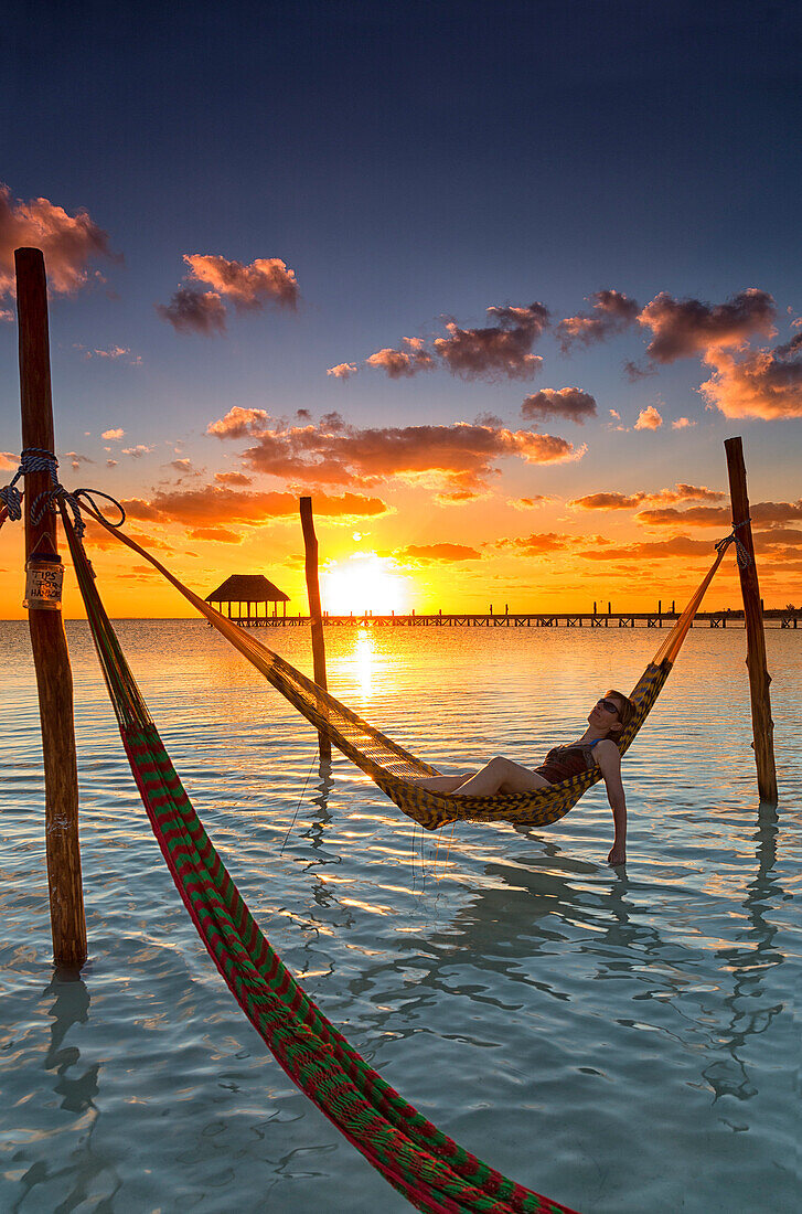 Woman lying in hammock at sunset, Holbox Island, Cancun, Yucatan, Mexico