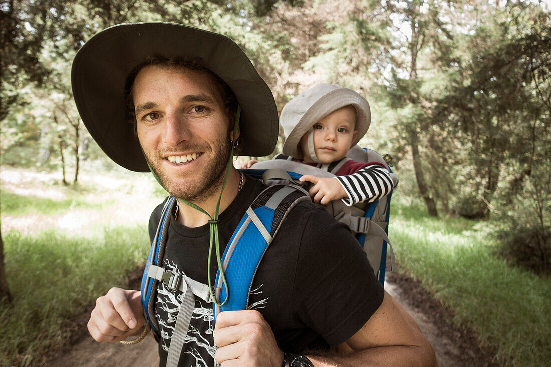 Man and his baby girl in carrier at hiking trail in Rancho Santa Elena, Hidalgo, Mexico