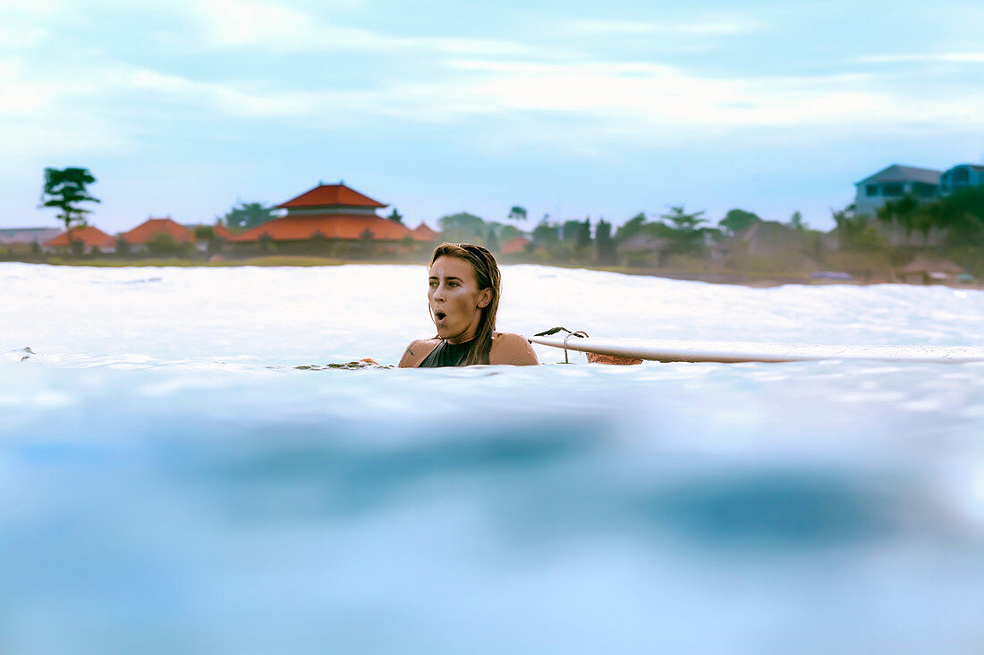 View of surfer girl swimming in sea during daytime, Changgu, Bali, Indonesia
