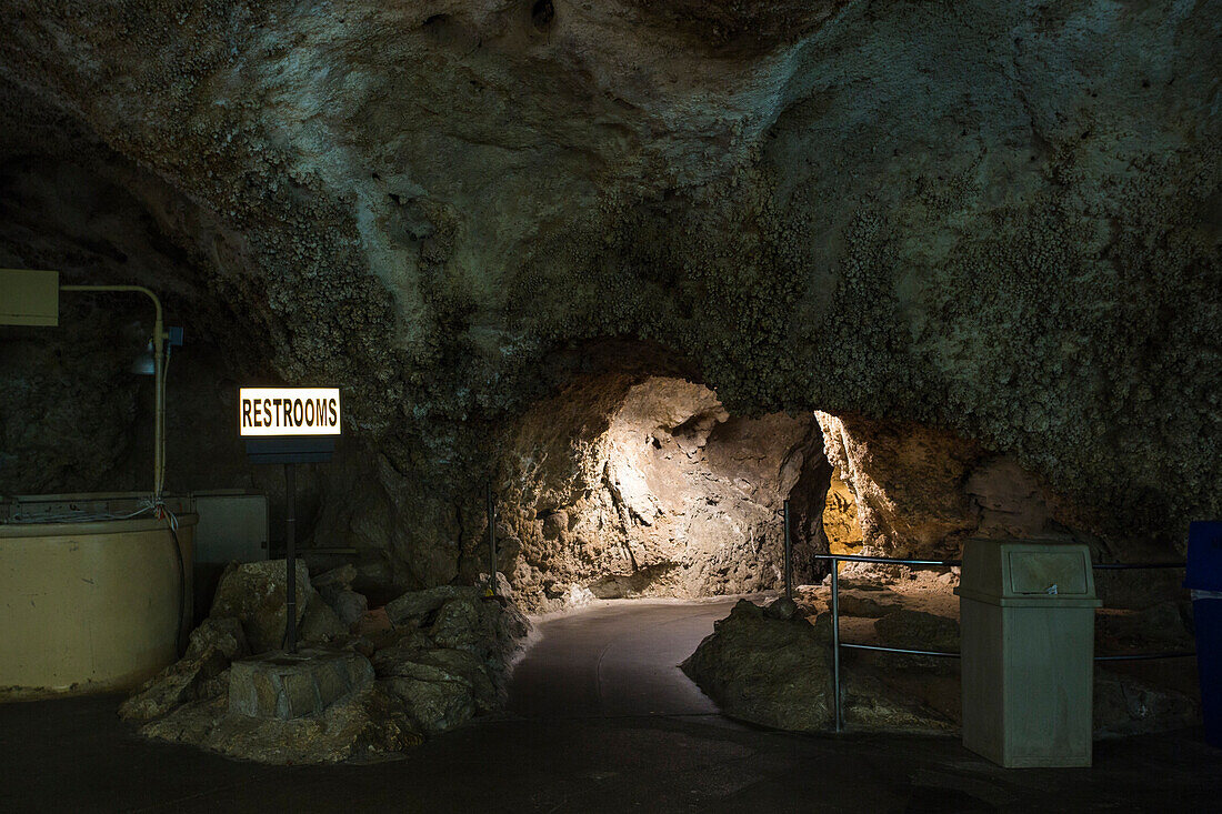 Ein beleuchteter Weg führt in einen Flur zum Badezimmer in einer riesigen unterirdischen Höhle