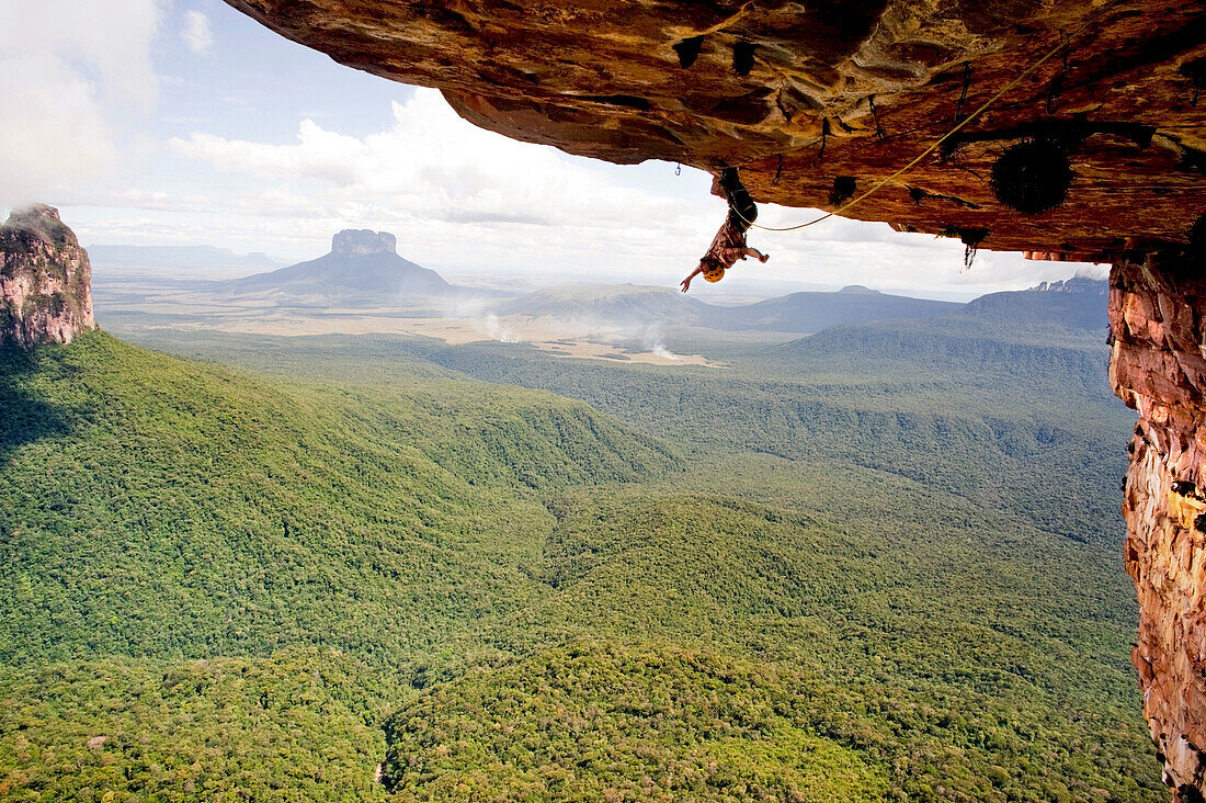 Adventurous rock climber hanging from rock ceiling, Amury Tepui, Bolivar, Venezuela