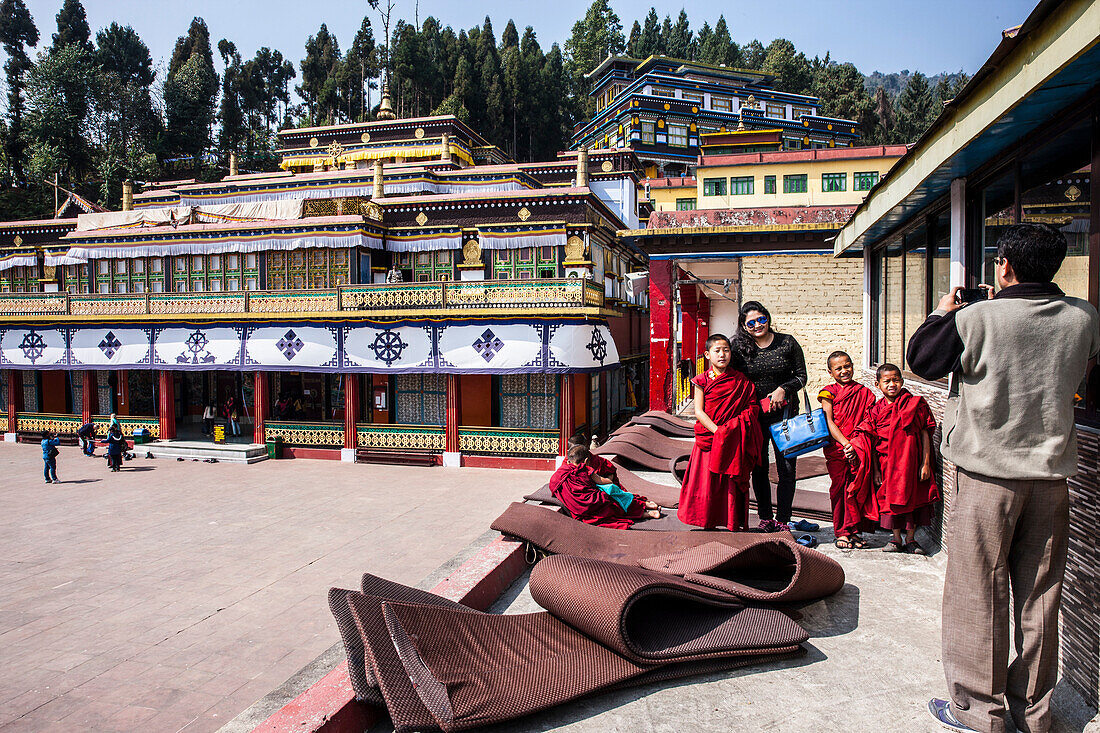 Visitors taking photos with Rumtek monks. Rumtek Monastery, also called the Dharmachakra Centre, founded by Wangchuk Dorje, 9th Karmapa Lama is a gompa located in the Indian state of Sikkim near the capital Gangtok. India.