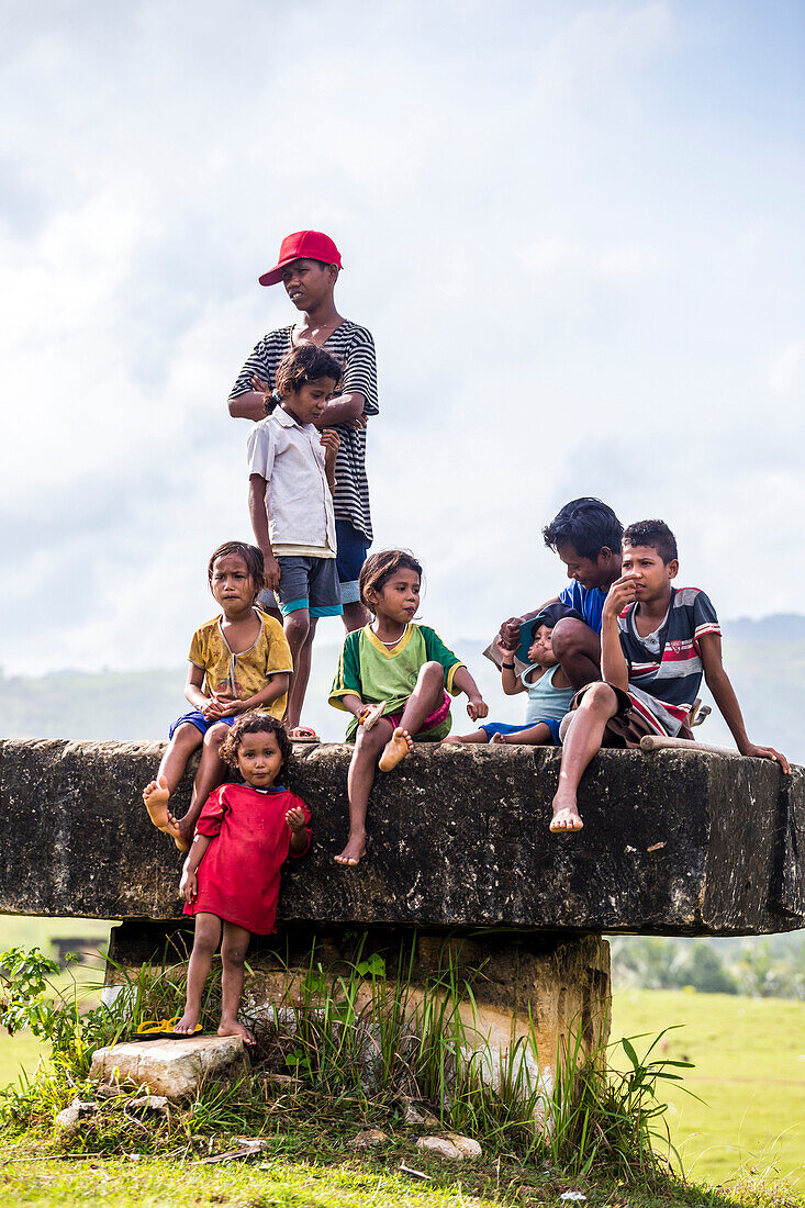 Gruppe von Kindern sitzen und stehen auf Stein Plattform, Sumba, Indonesien
