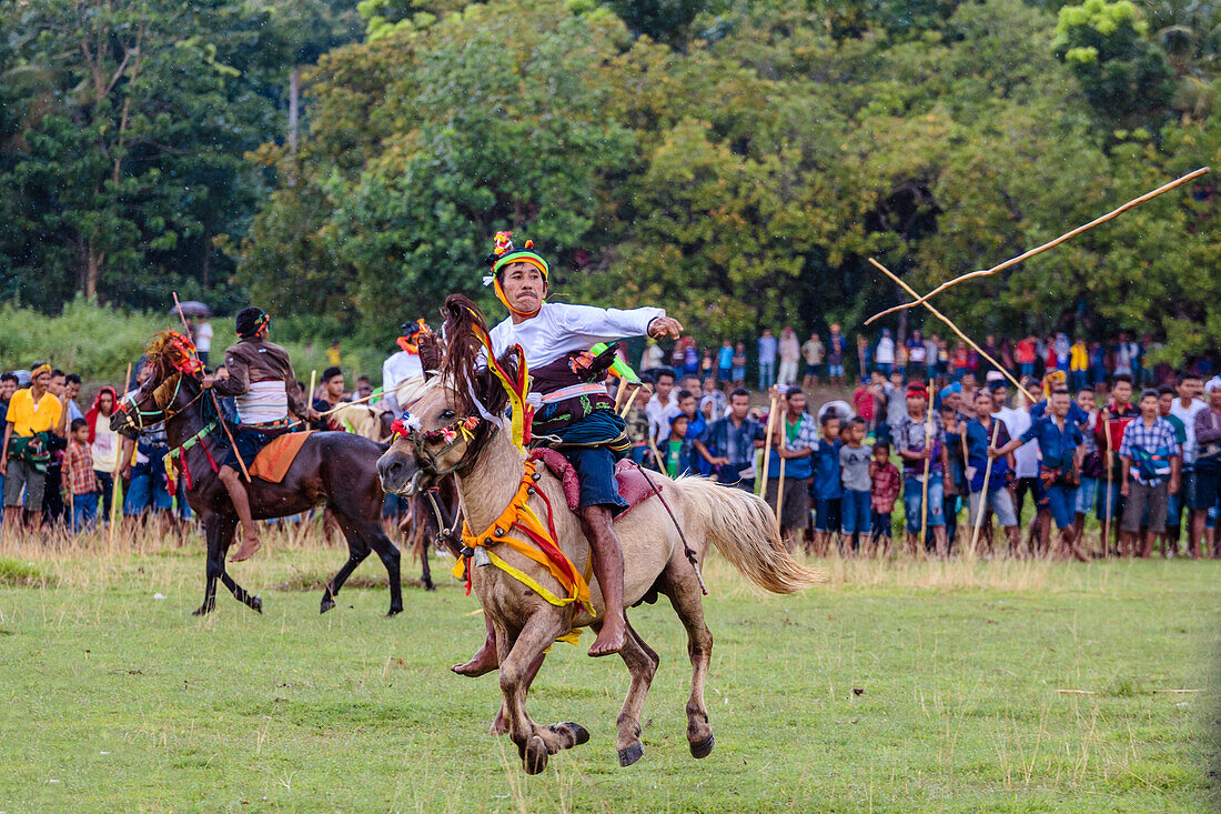 Männer reiten Pferde und werfen Speer auf Pasola Festival, Insel Sumba, Indonesien