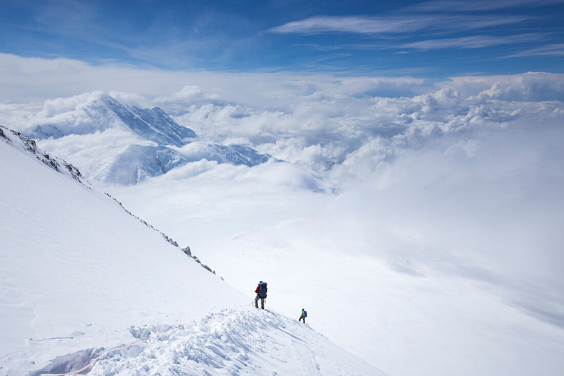 Bergsteiger steigen vom Denali-Pass mit hohem Lager in der Ferne ab. Denali in Alaska ist der höchste Gipfel Nordamerikas.