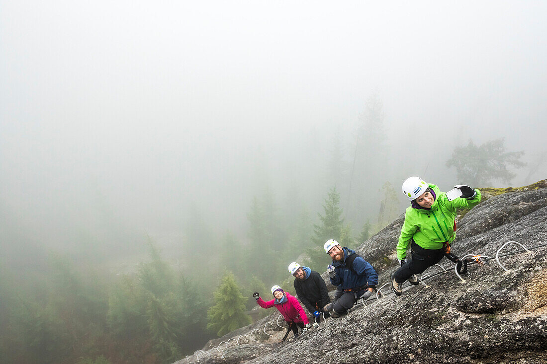 A women takes  selfie with a group of people who are enjoying a Via Ferrata in Squamish, British Columbia.